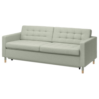 Jasnozielona sofa z drewnianymi nogami, kwadratowymi poduszkami i nowoczesnym designem.