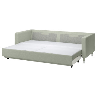 Zielona rozkładana sofa z chromowanymi nogami.